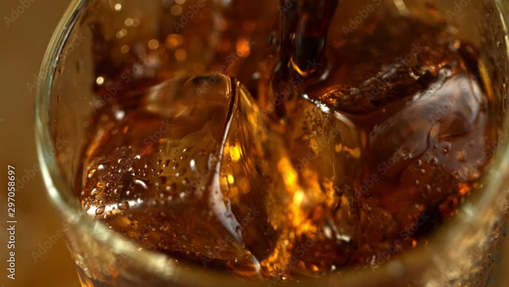 Super Slow Motion Macro Shot of Pouring Cola Lemonade into Glass with Ice Cubes at 1000fps. Super Slow Motion Macro Shot of Pouring Cola Lemonade into Glass with Ice Cubes at 1000fps.