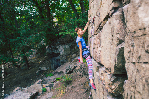 The girl climbs the granite rock.
