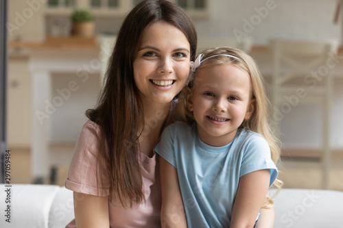 Head shot portrait smiling beautiful mother with cute little daughter