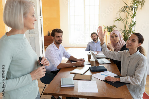 Young businesswoman training participant raise hand ask old mentor question