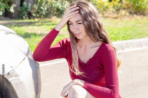 Slika na platnu Frustrated young woman checking pointing at car scratches and dents outdoors out