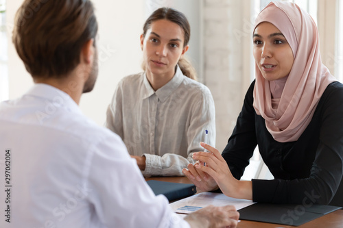 Fotografia Asian muslim female hr manager interviewing applicant consulting client