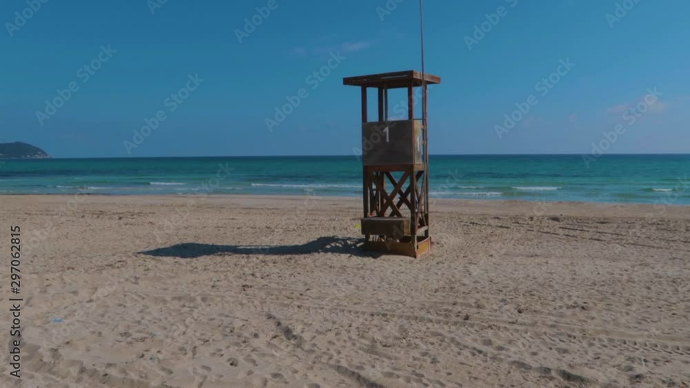 An isolated and desolated view of a lifeguard tower on the sand of the beach. Cala Millor, Majorca An isolated and desolated view of a lifeguard tower on the sand of the beach. Cala Millor, Majorca