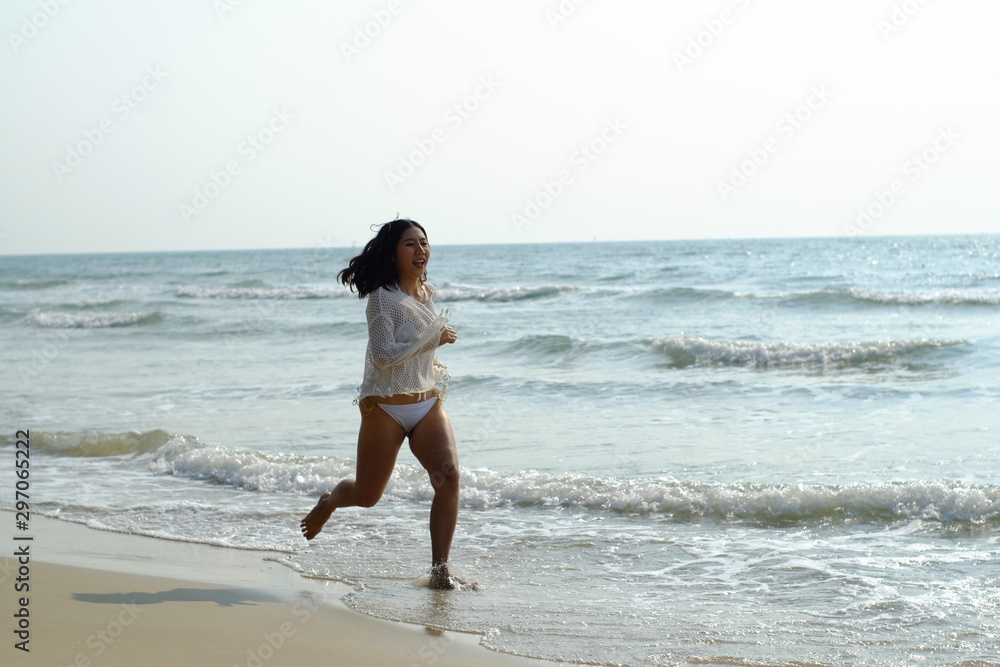 Beautiful young woman in white sportswear running on beach Beautiful young woman in white sportswear running on beach