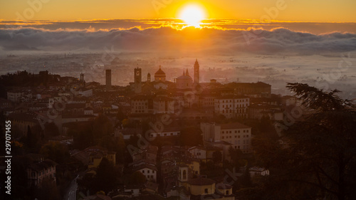 Bergamo, one of the most beautiful city in Italy. Amazing landscape of the old town and the fog covers the plain at sunrise. Fall season © Matteo Ceruti