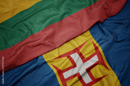 waving colorful flag of madeira and national flag of lithuania.