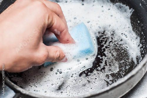 Hand wash the pan with a sponge and foamy detergent against grease.