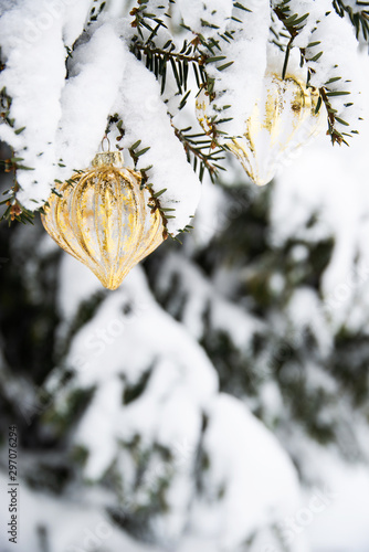 Decorated with golden ornaments Christmas tree on snow background. Merry Christmas and Happy Holidays greeting card. New Year. Noel. Winter xmas theme. Outdoor. 