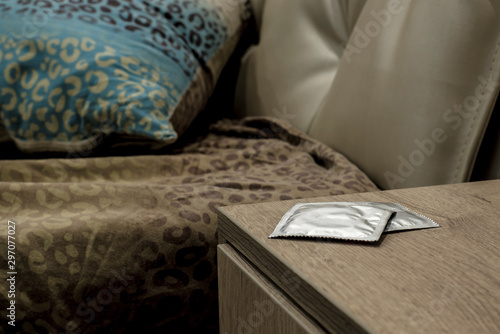 unused condoms lie on the bedside table