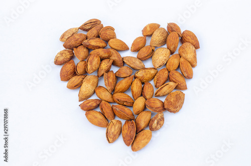 Almond nuts forming a heart-shape isolated on white