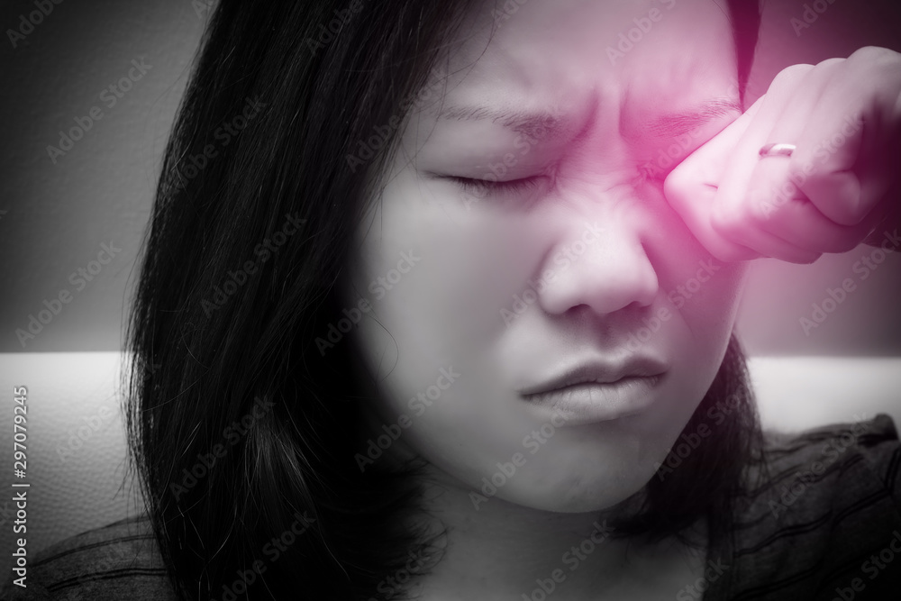 Asian woman rubbing her eye. Black and white tone and red spot on her