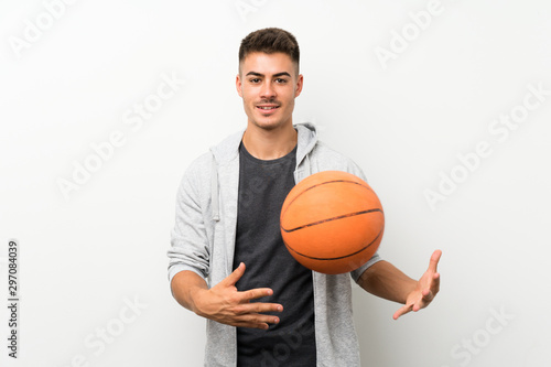 Sport man over isolated white wall with ball of basketball