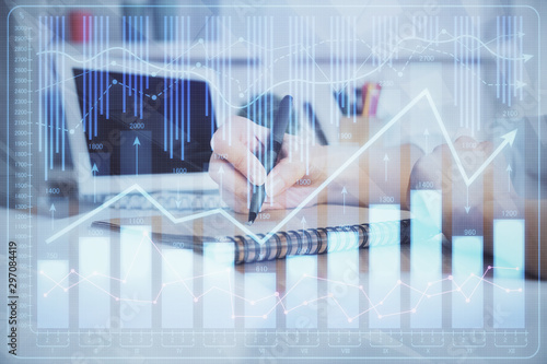 Financial graph displayed on woman's hand taking notes background. Concept of research. Double exposure © peshkova