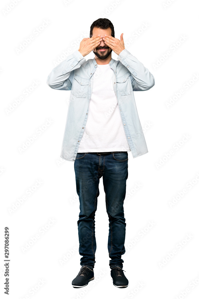 Full-length shot of Handsome man with beard covering eyes by hands over isolated white background Full-length shot of Handsome man with beard covering eyes by hands over isolated white background