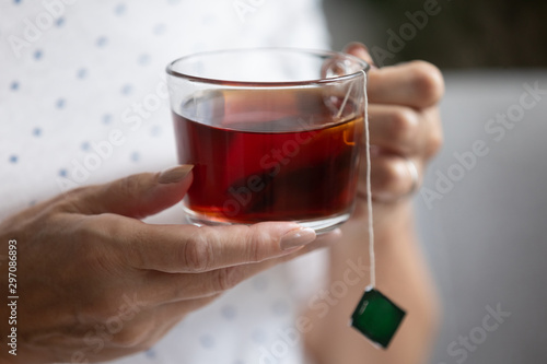 Middle aged woman holding cup of bag tea, closeup view
