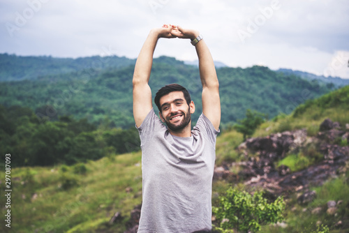 Portrait of young handsome man happy and smiling,Travel at outdoor,Hand raise up