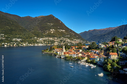 Panoramic top view of Lake Como. Lombardy, Italy. The small town of Torno. Autumn season. Perfect clear blue sky. Boats parked off the coast