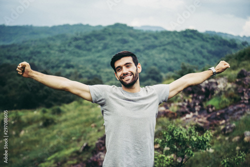 Portrait of young handsome man happy and smiling,Travel at outdoor,Hand raise up