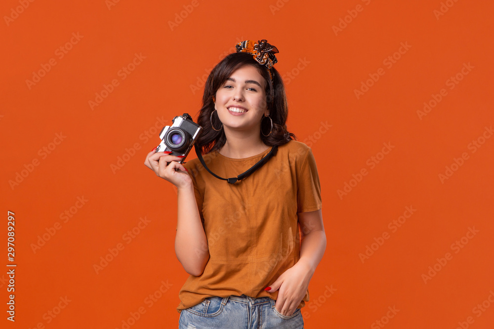 Obraz premium Happy brunette woman is happy to shoot with her camera.