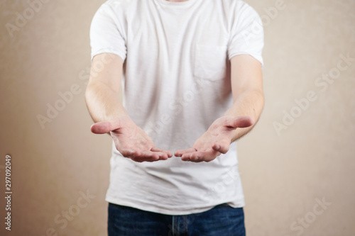 man in a white t shirt holds out empty hands