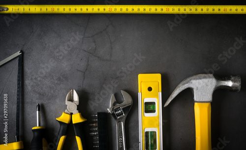 Obraz na płótnie yellow hardware tools on black concrete background with some space for text w salonie