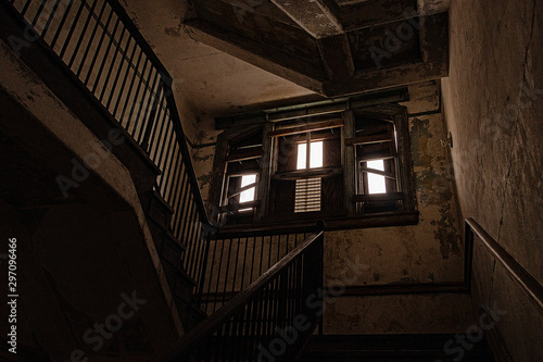 wooden stair case in boarded up, dilapidated house