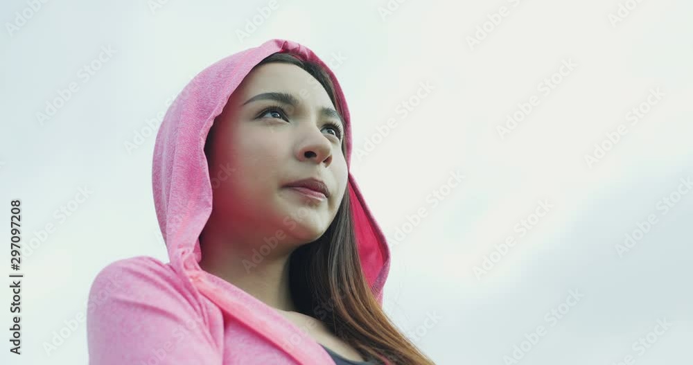 Closeup portrait of young positive sporty female looking forward with pink sky on the background. Closeup portrait of young positive sporty female looking forward with pink sky on the background.