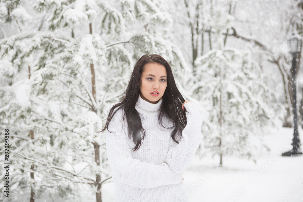 Girl in white sweater or pullover in winter snow covered park Girl in white sweater or pullover in winter snow covered park