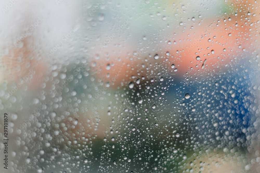 Blurred rainy window with red bokeh light