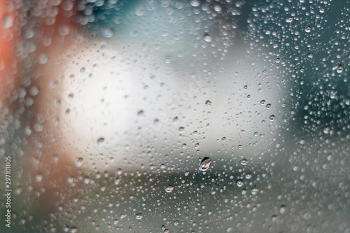 Blurred rainy window with red bokeh light