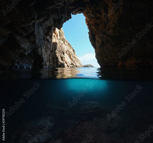 Under a rocky natural arch on the shore of the Mediterranean sea, split view over and underwater, Spain, Costa Brava, Catalonia, Palamos, Cala Foradada © dam