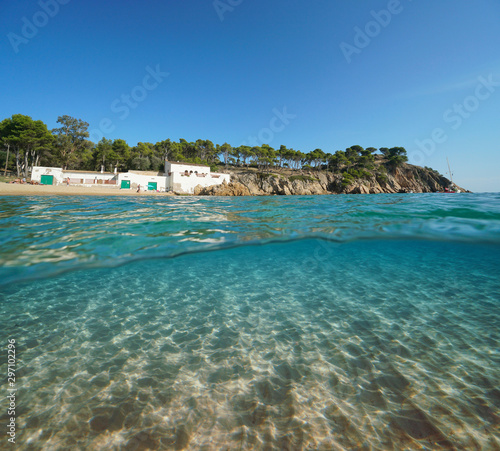 Spain Mediterranean coast with an old house on the beach and sand underwater sea, Costa Brava, Catalonia, Palamos, split view over and under water surface