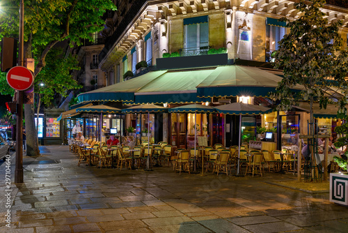 Fototapeta Naklejka Na Ścianę i Meble -  Boulevard San-German with tables of cafe in Paris at night, France