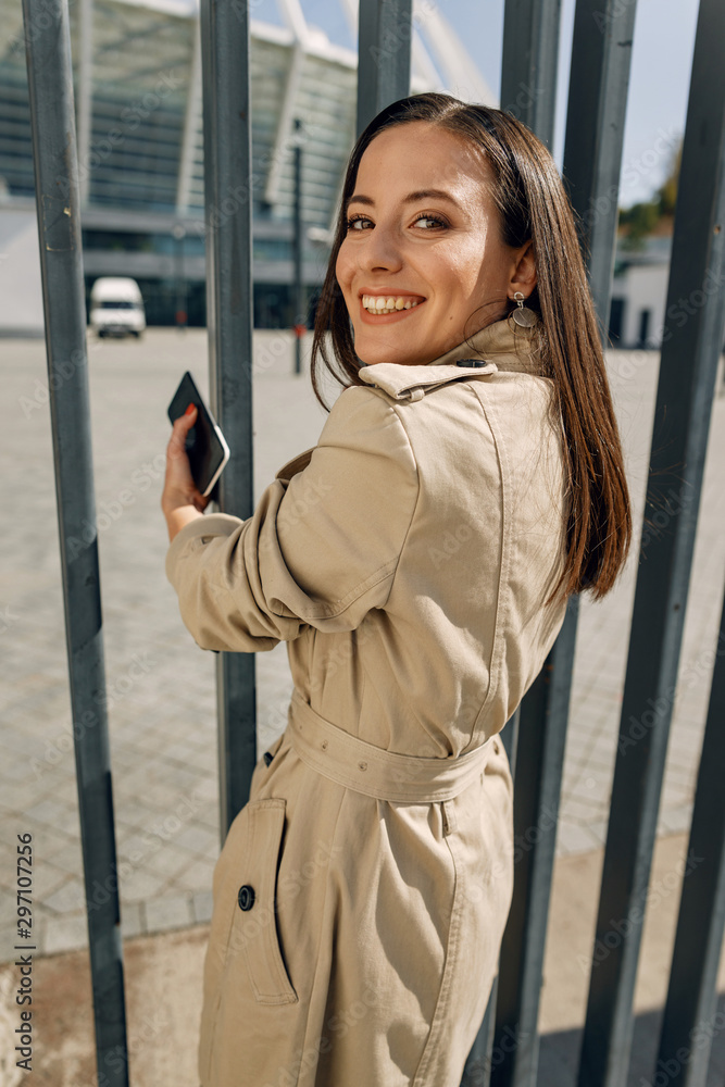 Fototapeta premium Charming young woman standing near metal support