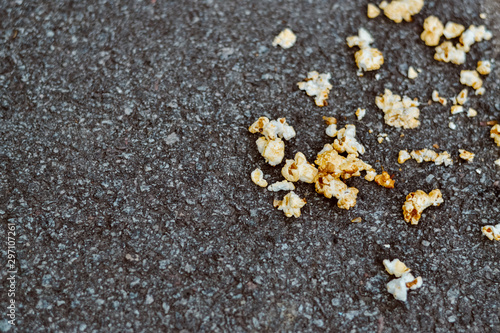 scattered popcorn on gray asphalt