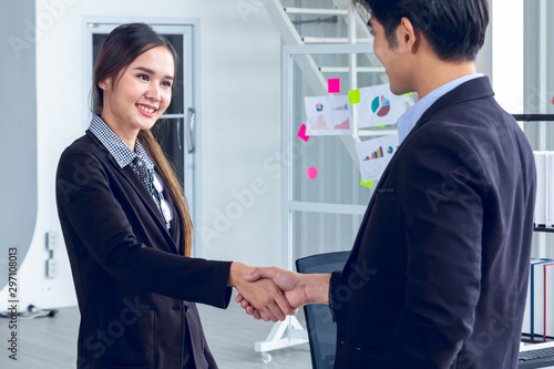 Wallpaper Mural Young Asian Businesspersons are standing and handshake about a financial business concept to agree on trade proposals within the modern office Torontodigital.ca