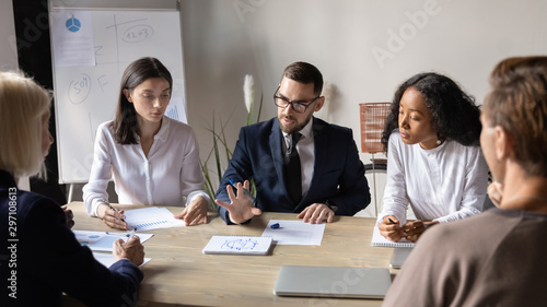 Focused businessman leader explaining corporate strategy during team briefing