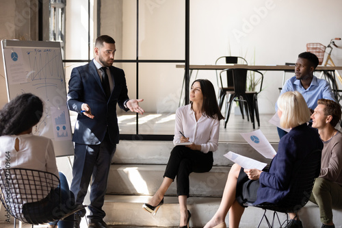 Cuadro en lienzo Confident male executive coach speaking to employees group during workshop