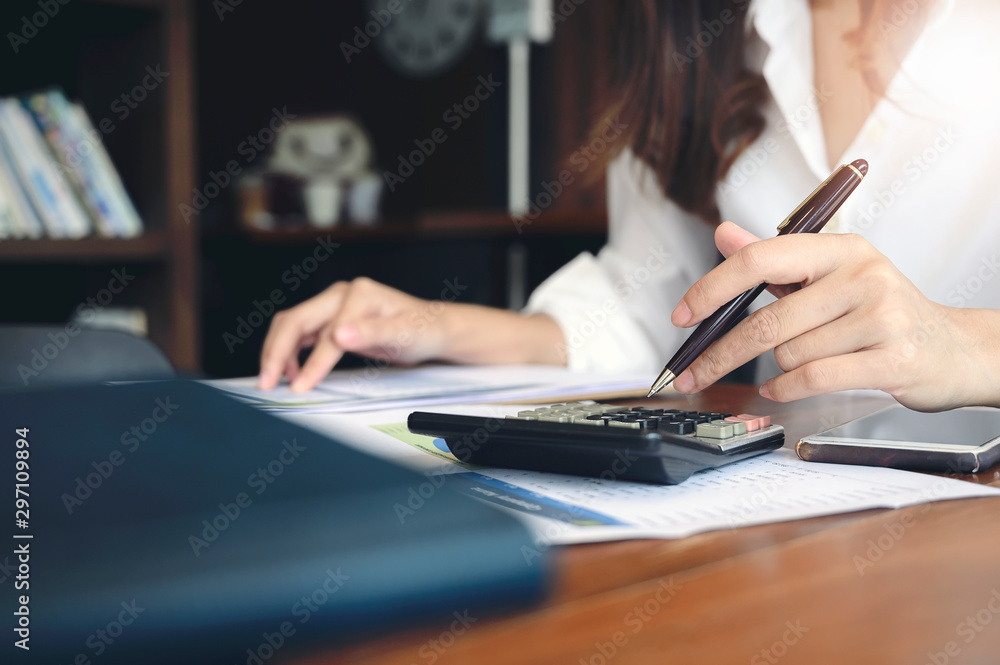 Woman using calculator at office desk. Woman using calculator at office desk.