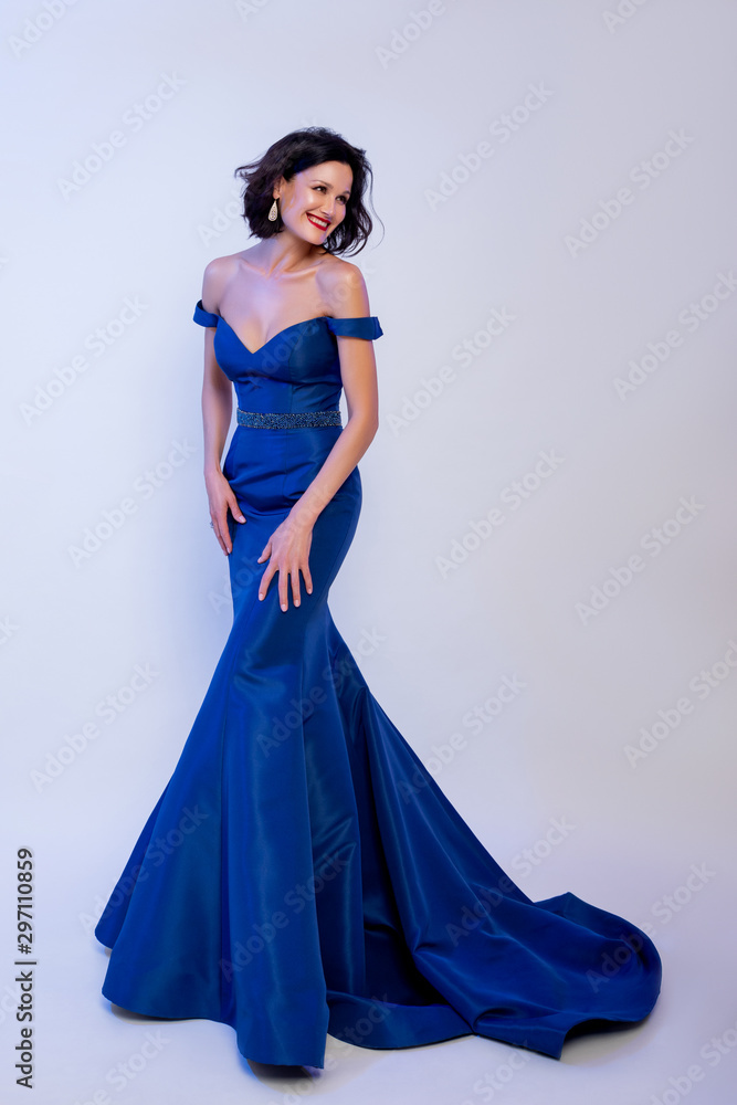 Fototapeta premium fashionable woman in a blue dress on the floor.