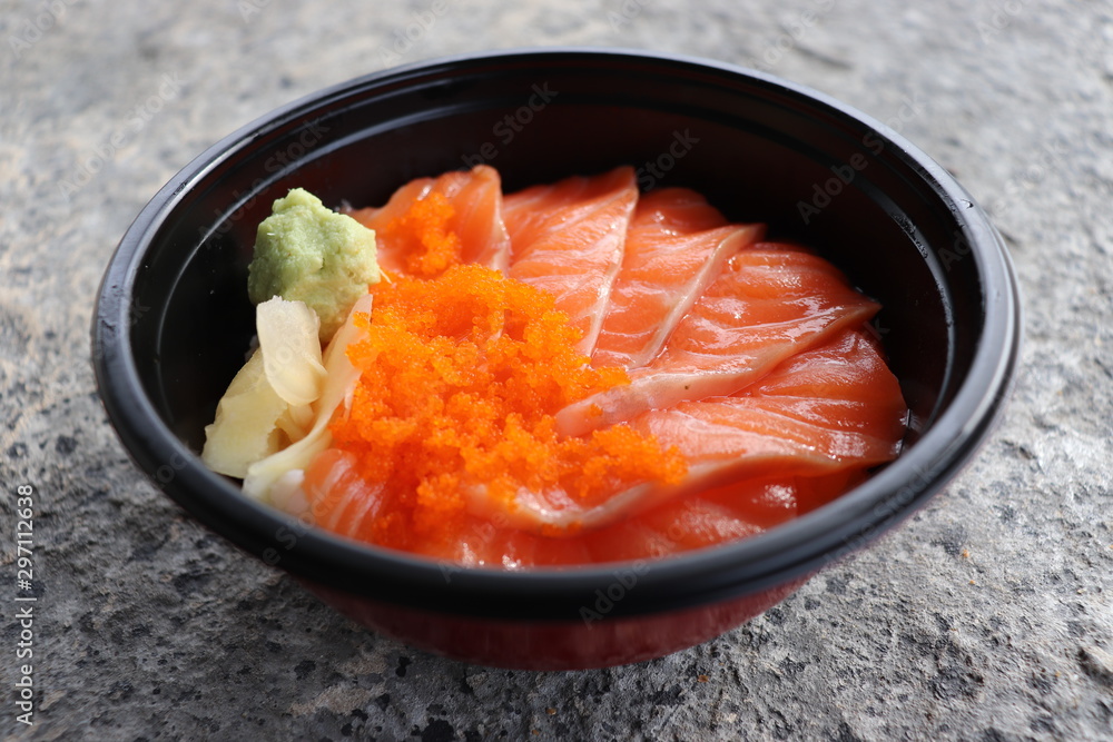 Fresh Salmon slices Include Shrimp eggs Pickled Ginger Wasabi In a black bowl , nutrition delicious ready for eat closeup on stone background Fresh Salmon slices Include Shrimp eggs Pickled Ginger Wasabi In a black bowl , nutrition delicious ready for eat closeup on stone background