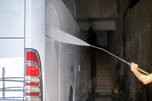 bus get washed from a washer with water jet in garage  photo