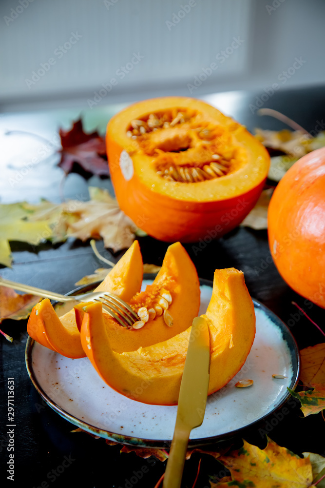 cut pumpkin on a plate with cutlery on the table cut pumpkin on a plate with cutlery on the table