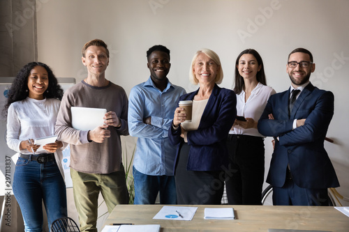 Happy confident diverse businesspeople stand together in office, team portrait