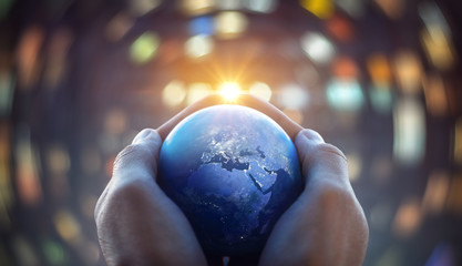 The globe Earth in the hands of man against the night city. Concept on business, politics, ecology and media. Earth day abstract background. Elements of this image furnished by NASA.
