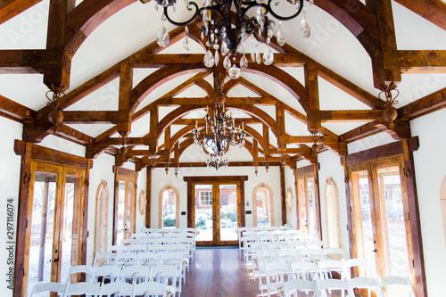 фотографія wedding venue interior with white walls and ceiling with wooden beams and ornate
