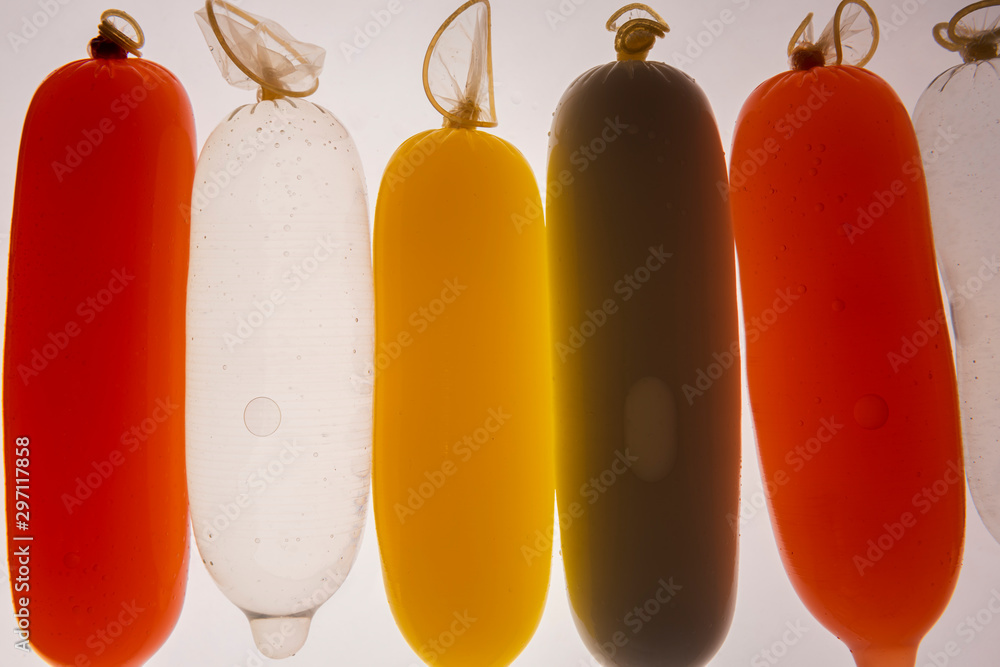 Condoms filled with colorful water, isolated on a white background. Condoms filled with colorful water, isolated on a white background.