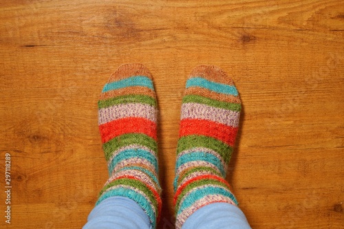 woolen socks on wooden floor, Legs in knitted socks as a symbol of country life, winter cosy scene