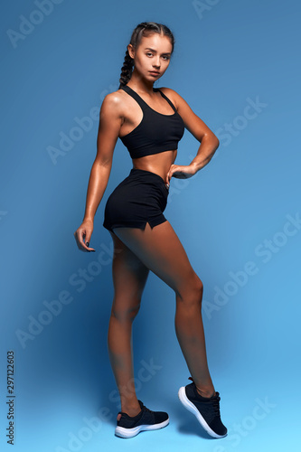 awesome brunette fit girl is keen on fitness, woman is good at sport. isolated blue background, studio shot. girl is fond of professional , amature sport © the faces