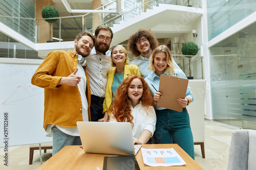 Wallpaper Mural Group of young creative designers in casual clothes, gathered to take photo in bright lighted modern office, stare ahead with broad smiles, shot from bellow Torontodigital.ca
